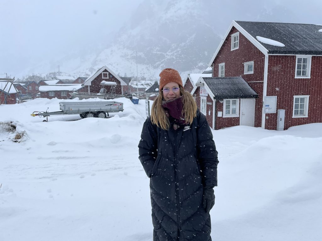 Karen vor einem roten Schwedenhaus mit ganz viel Schnee.