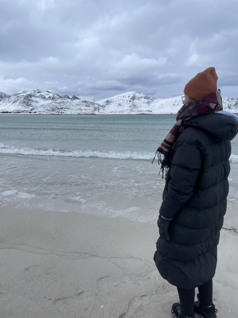 Karen, wie sie auf einen See schaut umgeben von Schnee
